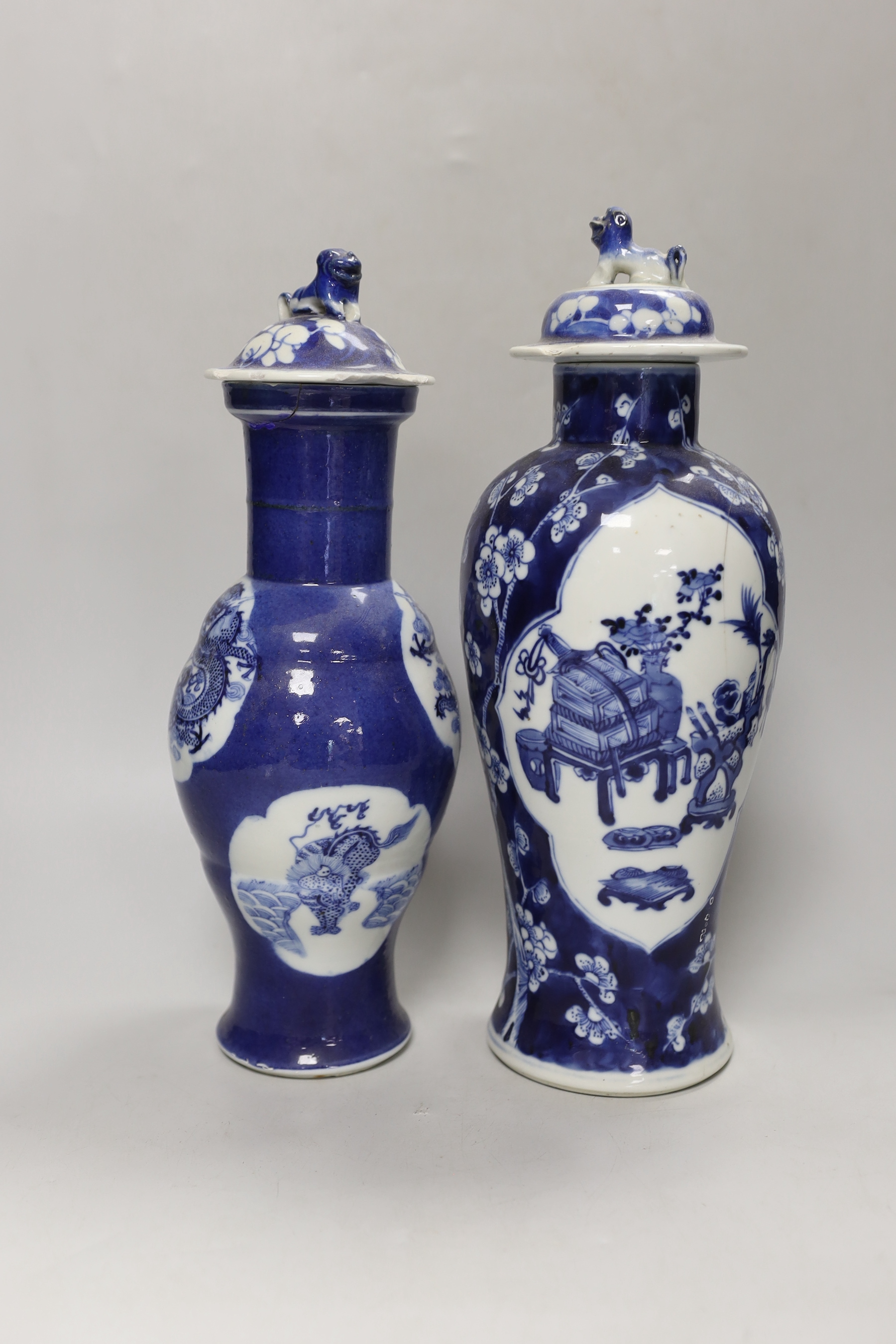 Two 19th century Chinese blue and white vases and covers, one with a dragon cartouche, the other a floral cartouche, tallest 34cm high